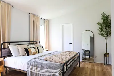 a bedroom with a large bed and a mirror at Heated pool house with mini golf 10 min to Disney in Orlando