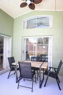 a dining room with a table and chairs and a ceiling fan at Heated pool house with mini golf 10 min to Disney in Orlando