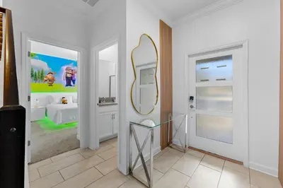 a white bathroom with a mirror and a sink at Disney Getaway Prime Location Themed Rooms in Kissimmee