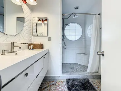a white bathroom with a shower and a sink at La Casa Mediterranean! 3 Bedroom Condo Near Disney! in Kissimmee