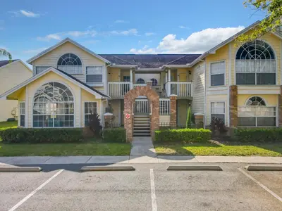 a large yellow house with a driveway at La Casa Mediterranean! 3 Bedroom Condo Near Disney! in Kissimmee