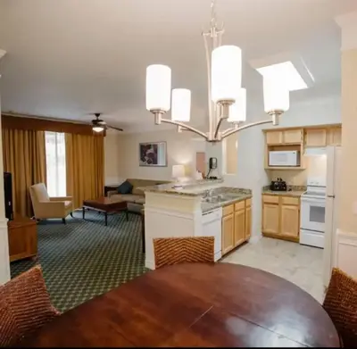 a kitchen and living room with a table and a chandelier at Paradise island near Disney in Kissimmee
