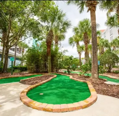 a green golf course with palm trees in a resort at Paradise island near Disney in Kissimmee