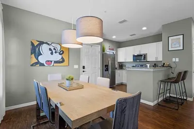 a kitchen and dining room with a table and chairs at Disney World Charm Home 4BR and 3BA! in Kissimmee