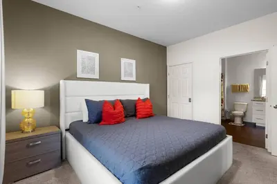 a bedroom with a bed with red and blue pillows at Disney World Charm Home 4BR and 3BA! in Kissimmee