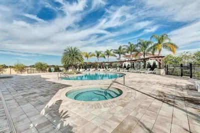 a swimming pool in a courtyard with palm trees at Disney World Charm Home 4BR and 3BA! in Kissimmee