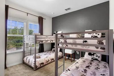 a bedroom with two bunk beds and a window at Disney World Charm Home 4BR and 3BA! in Kissimmee