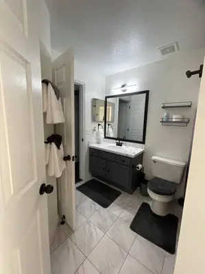 a bathroom with a sink and a toilet and a mirror at Resort Community 4 Bedroom Family Home, Pool & 15 Min Disney in Kissimmee