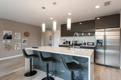 a kitchen with a large island with bar stools at Family and Fun Home with Splash Pool at Le Reve 08 in Kissimmee
