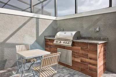 a kitchen with a grill and a table and chairs at Family and Fun Home with Splash Pool at Le Reve 08 in Kissimmee
