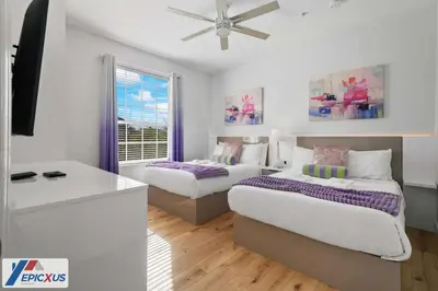a bedroom with two beds and a ceiling fan at The Epic Chicago Vista Cay Orlando in Orlando