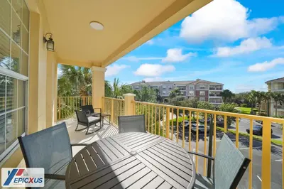 a patio with a table and chairs on a balcony at The Epic Chicago Vista Cay Orlando in Orlando