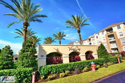 a hotel with palm trees in front of a building at The Epic Chicago Vista Cay Orlando in Orlando