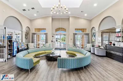 a large room with couches and chairs and a chandelier at The Epic Chicago Vista Cay Orlando in Orlando