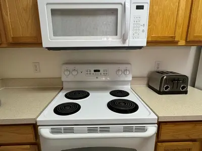 a white stove top oven in a kitchen with a microwave at 2778 Windsor Hills 3 Bed Condo- All Included in Orlando