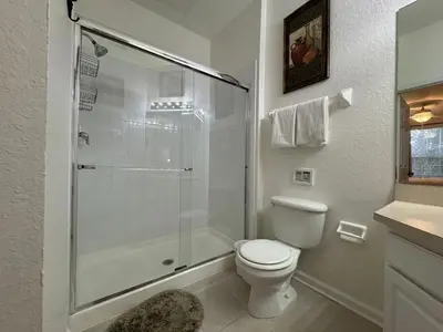 a bathroom with a toilet and a glass shower at 2778 Windsor Hills 3 Bed Condo- All Included in Orlando