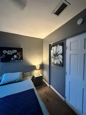 a bedroom with a blue bed and a white door at Downtown Private Deluxe Room in Orlando