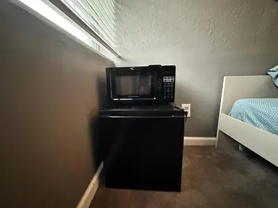 a microwave sitting on top of a refrigerator in a room at Downtown Private Deluxe Room in Orlando