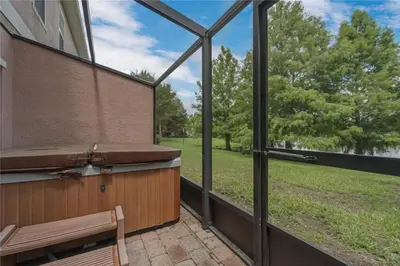 a screened in porch with a bench and a view of a park at Enjoy my cozy house next to Disney in Kissimmee
