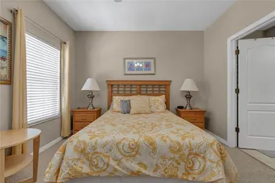 a bedroom with a bed and two tables and two lamps at Enjoy my cozy house next to Disney in Kissimmee