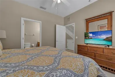 a bedroom with a bed and a flat screen tv at Enjoy my cozy house next to Disney in Kissimmee