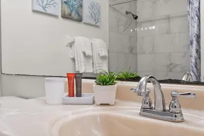 a bathroom sink with toothbrushes and other items on it at 3 Quartos + Piscina e Game Room em Orlando in Kissimmee