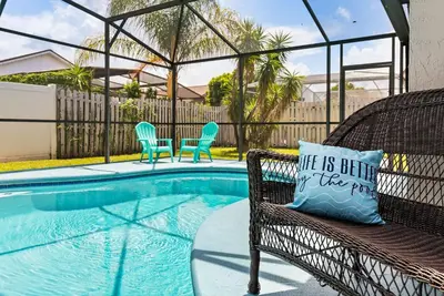 a pillow sitting on a bench next to a swimming pool at 3 Quartos + Piscina e Game Room em Orlando in Kissimmee