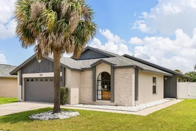 a palm tree in front of a house at 3 Quartos + Piscina e Game Room em Orlando in Kissimmee