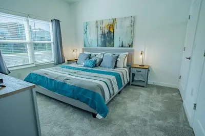 a bedroom with a large bed with blue sheets and pillows at Townhouse c/Piscina Priv. Perto da Disney in Kissimmee