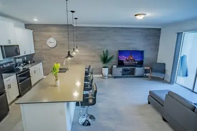 a kitchen and living room with a couch and a tv at Townhouse c/Piscina Priv. Perto da Disney in Kissimmee