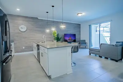 a kitchen with a sink and a living room at Townhouse c/Piscina Priv. Perto da Disney in Kissimmee