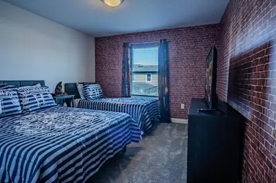 a bedroom with two beds and a brick wall at Townhouse c/Piscina Priv. Perto da Disney in Kissimmee