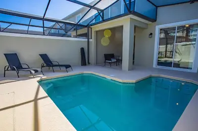 a swimming pool in a house with chairs around it at Townhouse c/Piscina Priv. Perto da Disney in Kissimmee