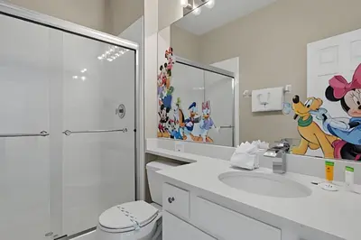 a bathroom with a sink and a toilet and a mirror at Casa Luxo 4Q c/ Piscina e Game Room Avengers in Orlando