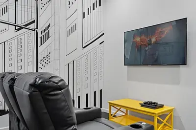 a black leather chair and a table in a room at Casa Luxo 4Q c/ Piscina e Game Room Avengers in Orlando