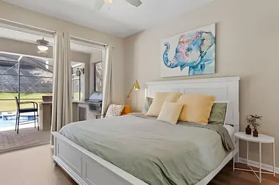 a bedroom with a large bed and a table at Casa Luxo 4Q c/ Piscina e Game Room Avengers in Orlando