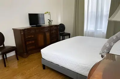 a bedroom with a bed and a dresser with a television at 6Q/5.5B Luxo Piscina Priv. Disney in Kissimmee