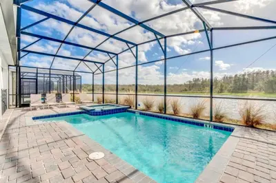 an indoor pool in a glass house with a view at Brand New House Private Lake View 3009 Protagonist home in Kissimmee