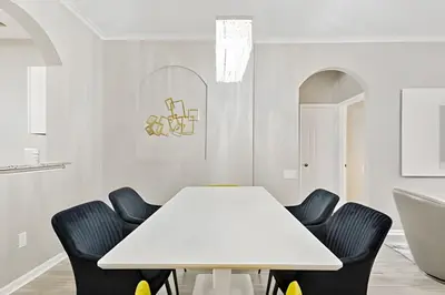 a white dining room with a white table and chairs at Familiar 3 Quartos Perto da Disney! in Orlando