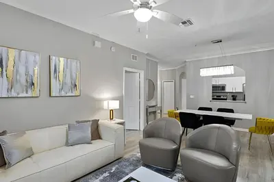 a living room with a couch and chairs and a table at Familiar 3 Quartos Perto da Disney! in Orlando