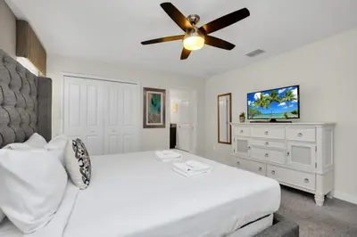 a bedroom with a white bed and a ceiling fan at 4804Crusoe townhouse in Kissimmee