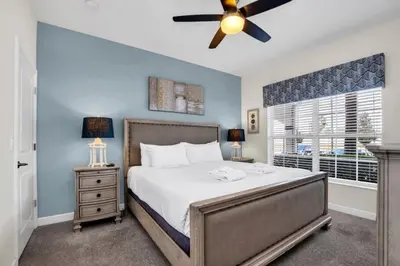 a bedroom with a bed with a ceiling fan and a window at 4804Crusoe townhouse in Kissimmee