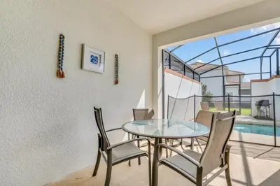 a dining room with a glass table and chairs at 4804Crusoe townhouse in Kissimmee