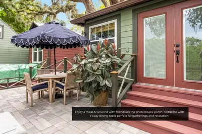 a porch of a house with a table and an umbrella at Mills Cottage in Orlando