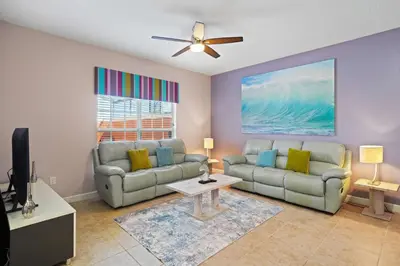 a living room with two couches and a tv at 8929 Candy Palm Road in Kissimmee
