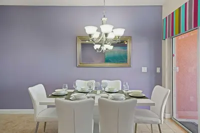 a dining room with a white table and white chairs at 8929 Candy Palm Road in Kissimmee