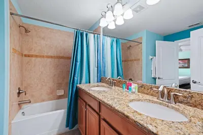 a bathroom with two sinks and a tub and a shower at 8929 Candy Palm Road in Kissimmee