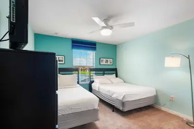 two beds in a room with blue walls at 8929 Candy Palm Road in Kissimmee
