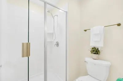 a white bathroom with a shower and a toilet at 4829Lullaby townhouse in Kissimmee