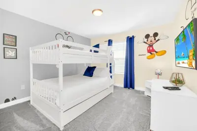 a white bedroom with a bunk bed and a desk at 4829Lullaby townhouse in Kissimmee